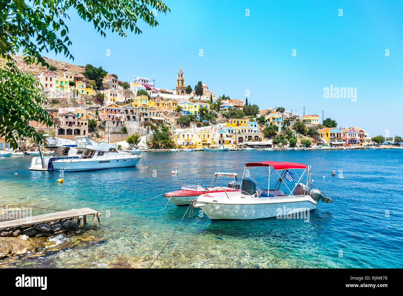 Verankerten Boote und bunten neoklassischen Häuser in der Bucht von Symi (Insel Symi, Griechenland) Stockfoto