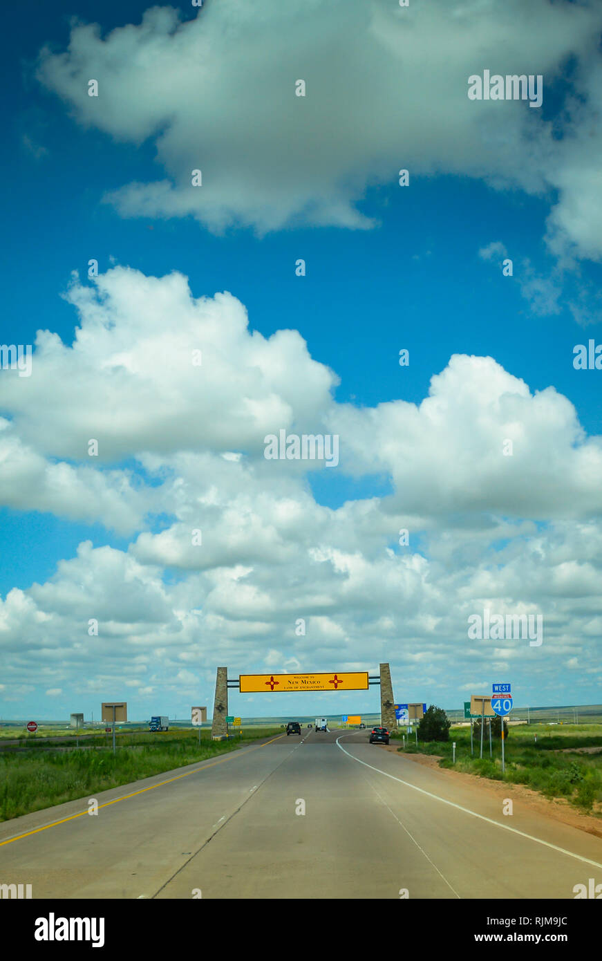 Blauer Himmel mit weißen Wolken Puffy führen zu der Fernen, Overhead gelb New Mexico State Line anmelden, auf 1-40 & Route 66, Texas verlassen Stockfoto