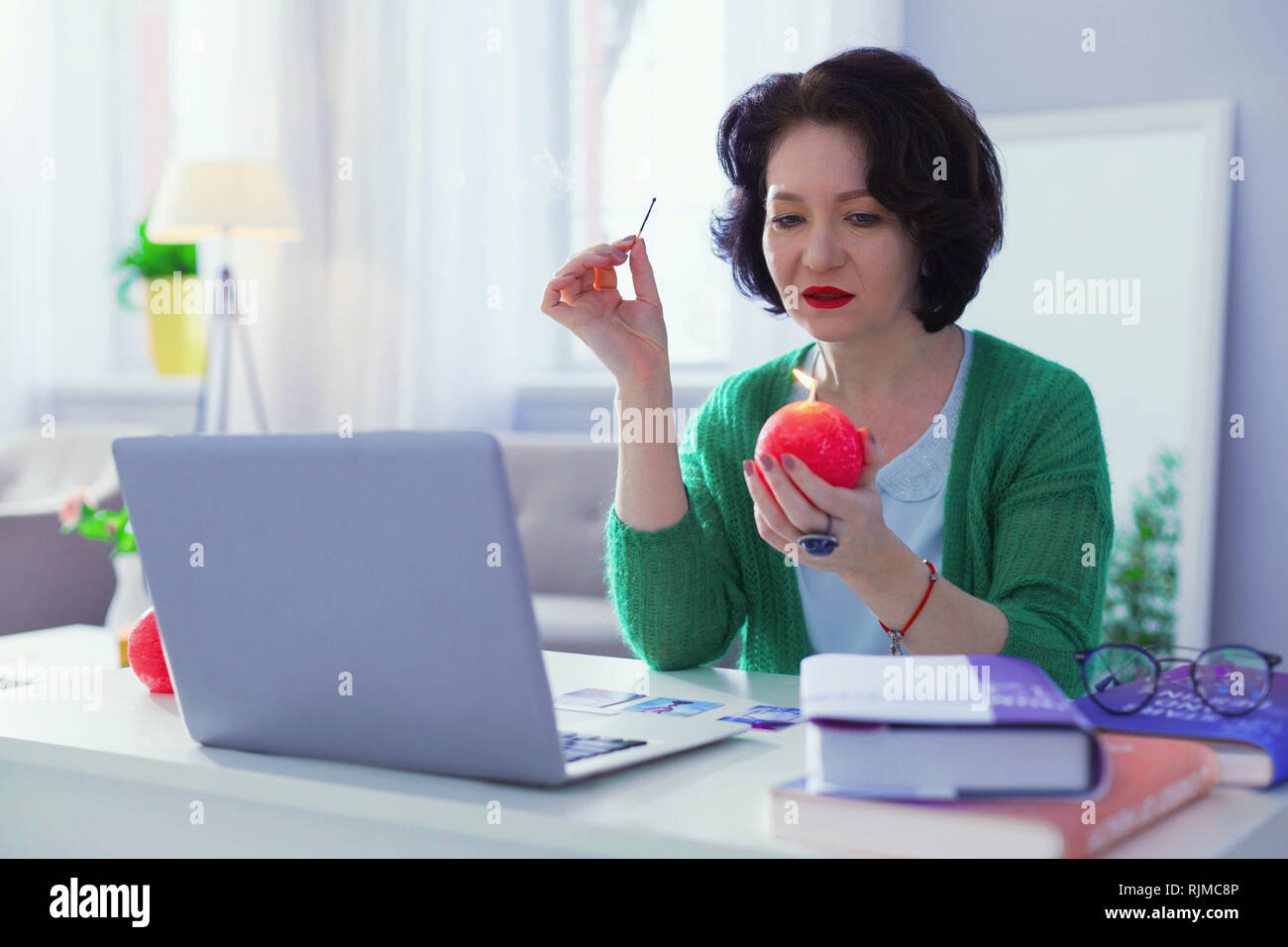 Smart nette Frau an der Kerze suchen Stockfoto