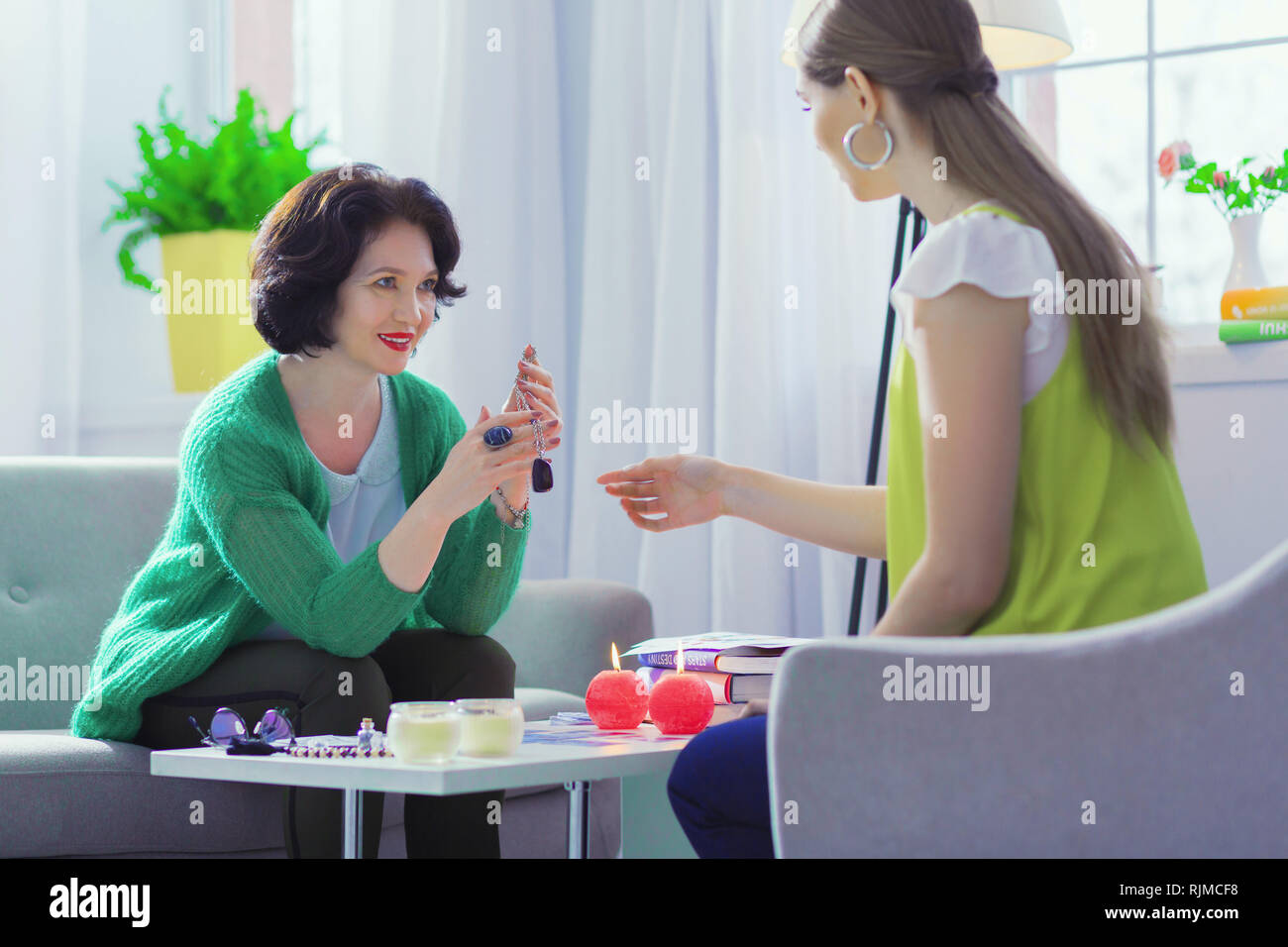 Positive freundliche Frau mit einem speziellen Amulett Stockfoto