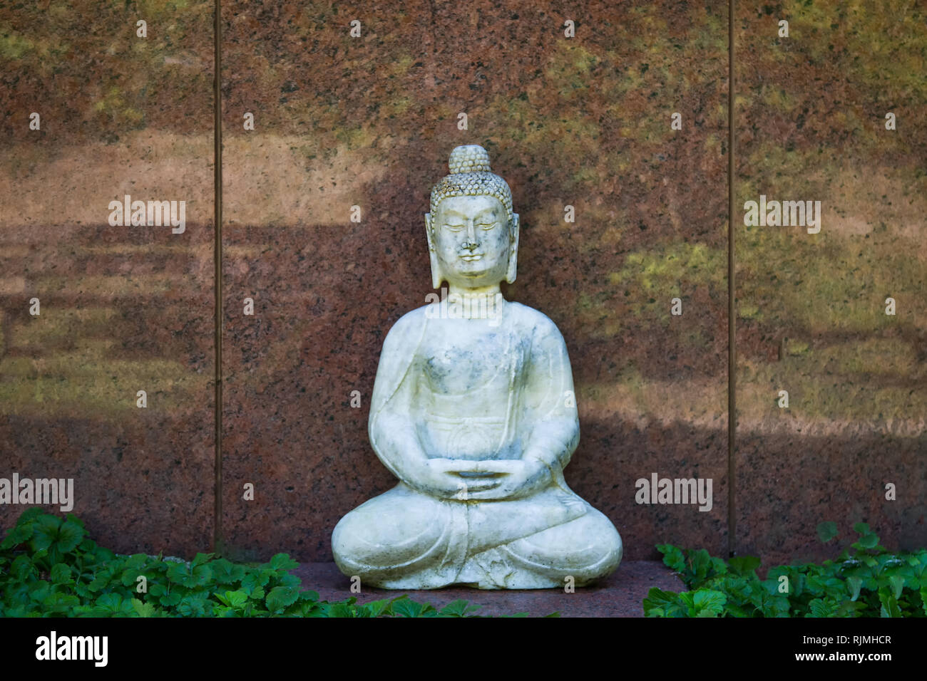 Buddha vor einem Marmor Grabstein Platte Stockfoto