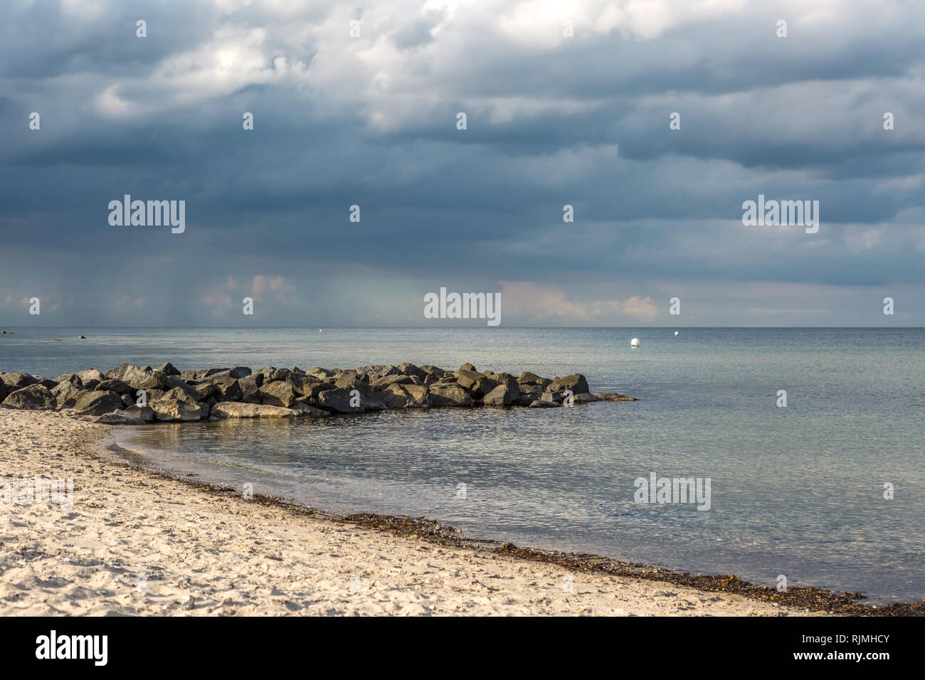 Ein Gewitter mit dunklen Wolken erhebt sich auf den Strand Stockfoto