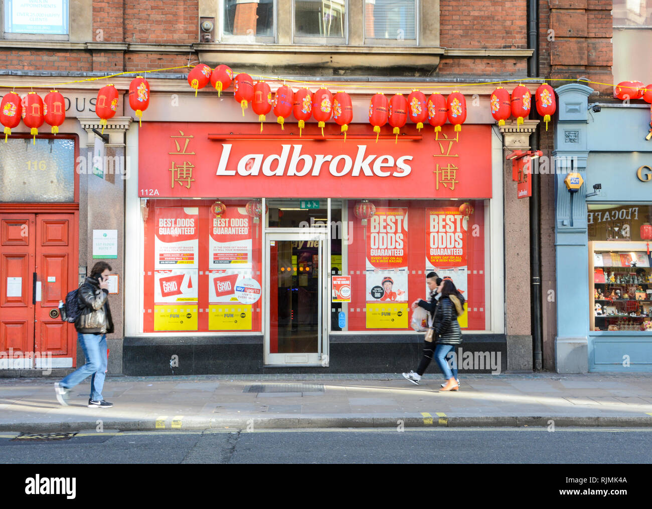 Jahr des Schweins chinesischen Neue Jahr Dekorationen außerhalb Ladbrokes Betting Office in Soho, London, UK Stockfoto