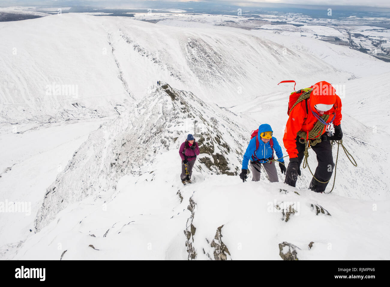 Kletterer und Bergsteiger auf ein Winter Traverse der scharfen Kante, eine Kante auf blencathra Berg im Nationalpark Lake District, Cumbria, Großbritannien Stockfoto