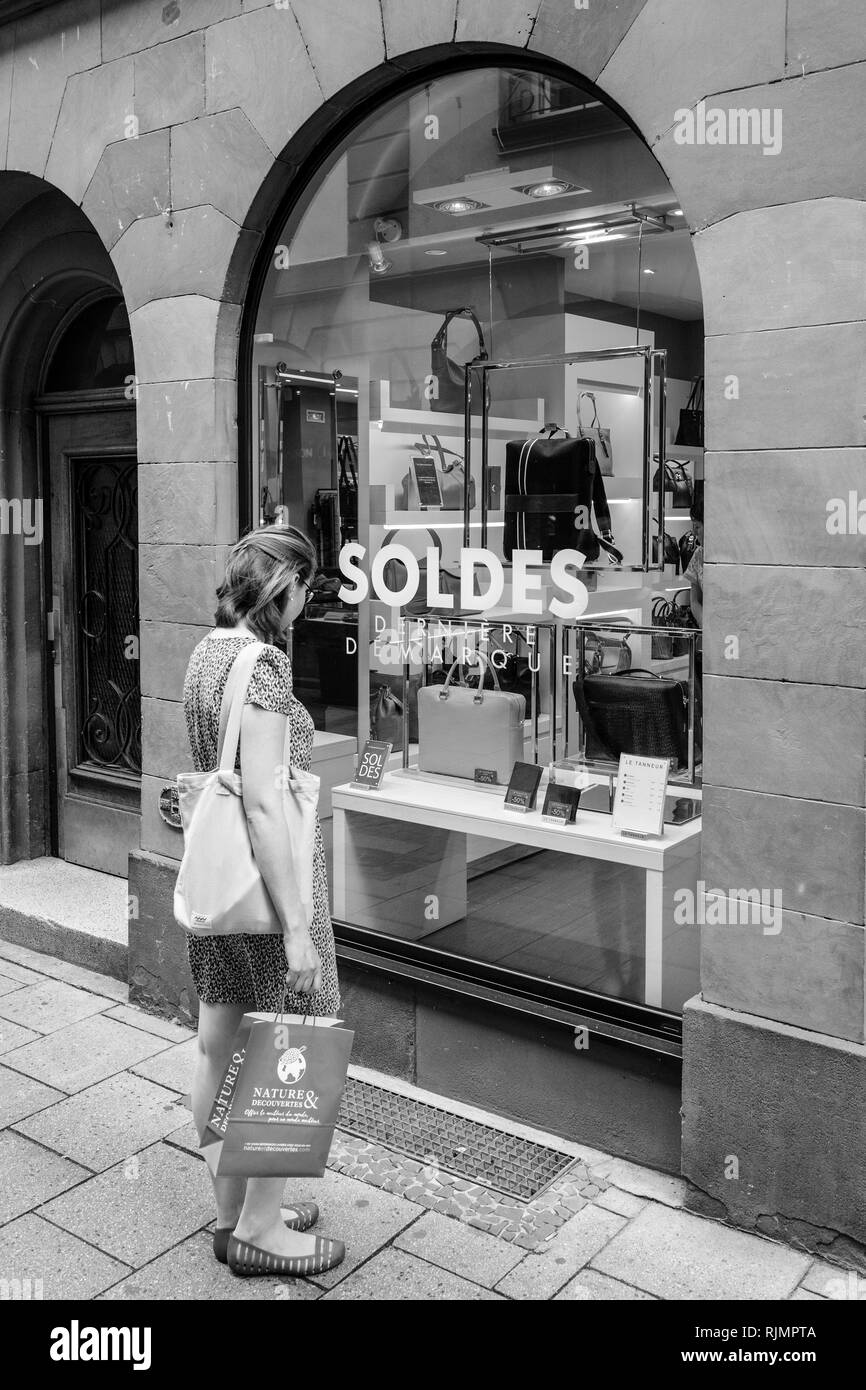 Straßburg, Frankreich, 22.Juli 2017: elegante französische Frau bewundern die Produkte aus Leder in Fashion Store Le tanneur mit großen Umsatz Soldes Aufkleber auf Fenster präsentieren - Schwarz und Weiß Stockfoto