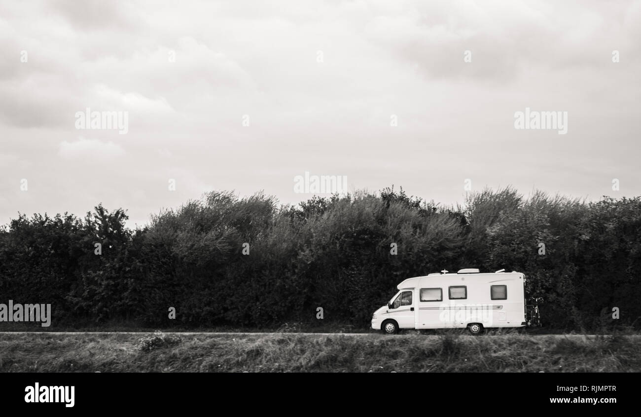 Schnelle RV Kameras van fahren auf der grünen Dünen im Euroeapn Netheralnds während der Feiertage - Schwarz und Weiß Stockfoto