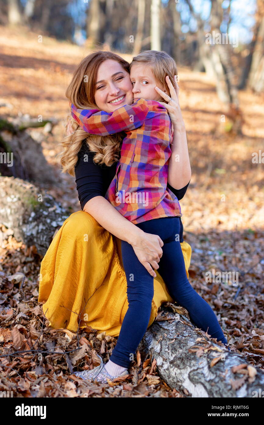 Glückliche Mutter und Tochter Umarmen im Herbst Natur Hintergrund Stockfoto