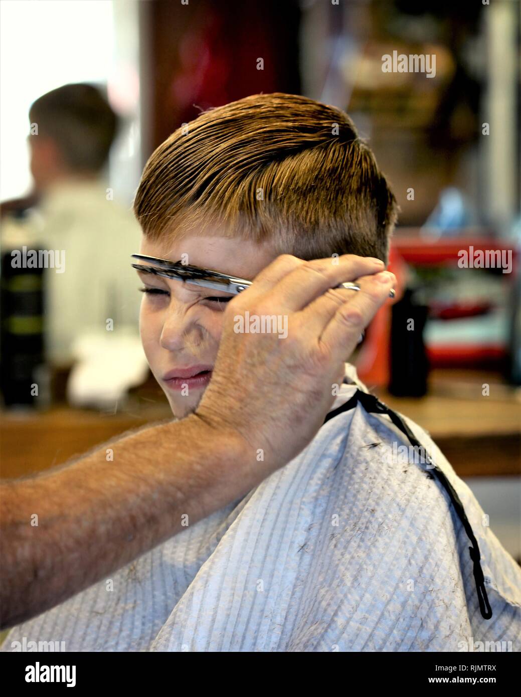 Junge Junge, Haarschnitt und sie ihm nicht gefällt Stockfoto