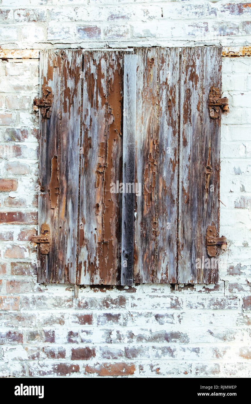Geschlossen braun rot Schälen von Holz- Fenster mit verrosteten Scharniere  aus Metall auf einem grungy weiße Mauer von einem alten, verlassenen  baufälligen Scheune verwitterten durch t Stockfotografie - Alamy