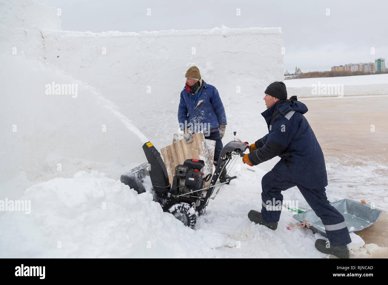 Arbeitnehmer beseitigt Schnee in einem Blizzard mit einem Schneepflug Stockfoto