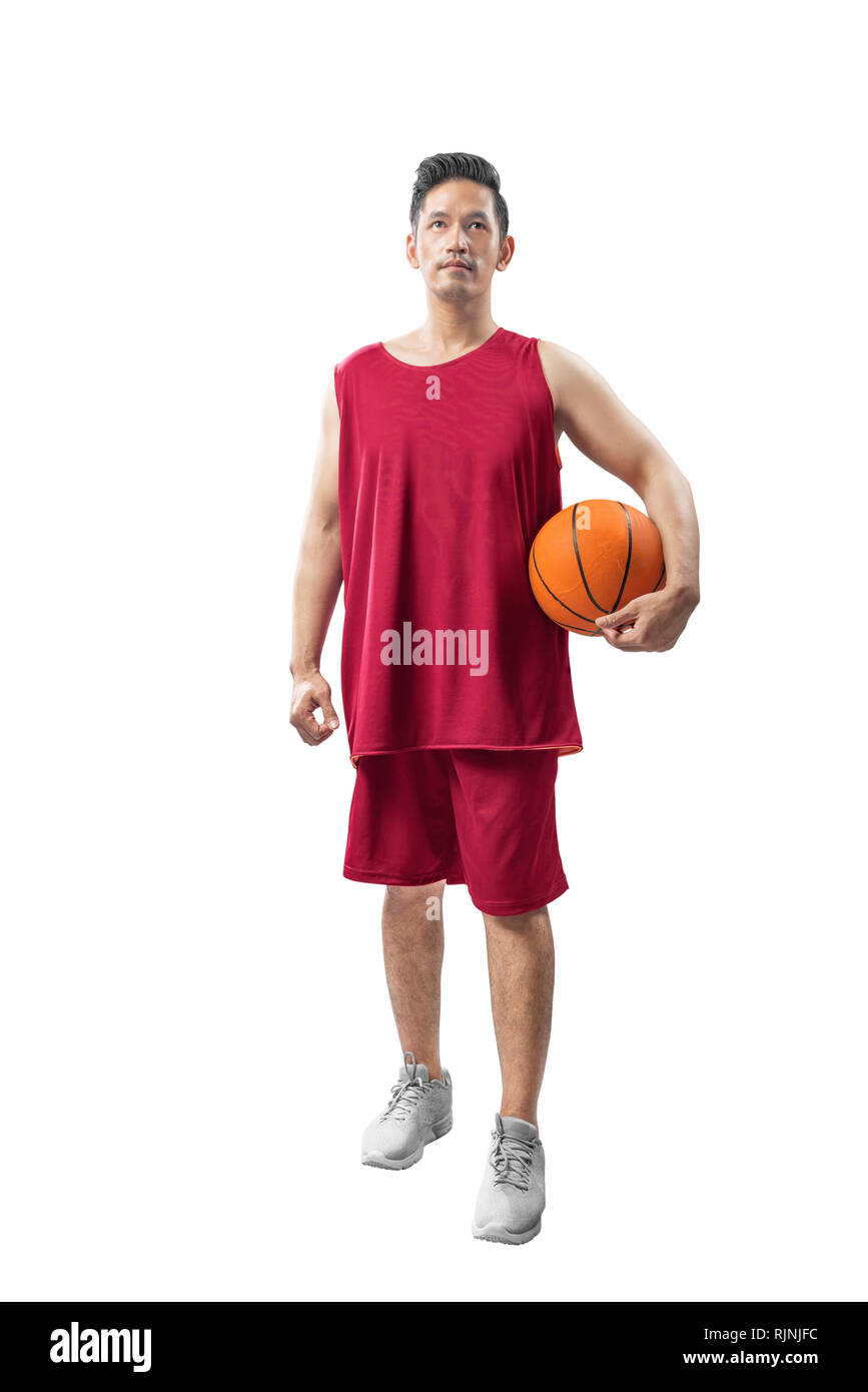 Portrait von asiatischen sportlicher Mann mit roten Uniform holding Basketball auf weißem Hintergrund Stockfoto