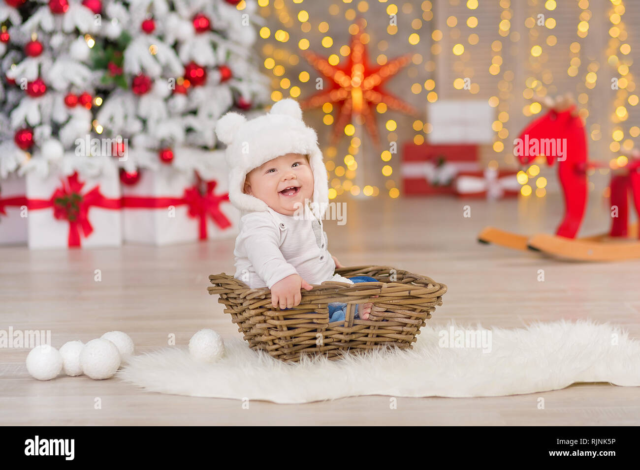 Schöne kleine baby boy feiert Weihnachten. Das neue Jahr Urlaub. Baby in  einem Weihnachten kostüm legere Kleidung mit Geschenken auf Fell in der  Nähe des Neuen Jahres tr Stockfotografie - Alamy