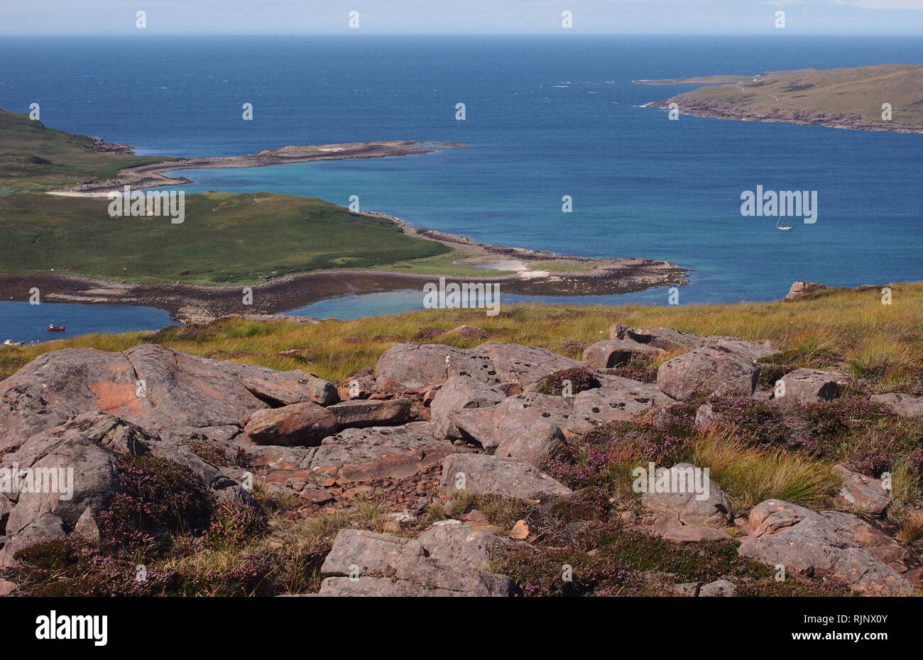 Ein Blick zur Insel Ristol, Reiff und Altandhu aus Meail Dearg, Schottland mit tiefblauen Meer mit Felsen und Heather im Vordergrund. Stockfoto