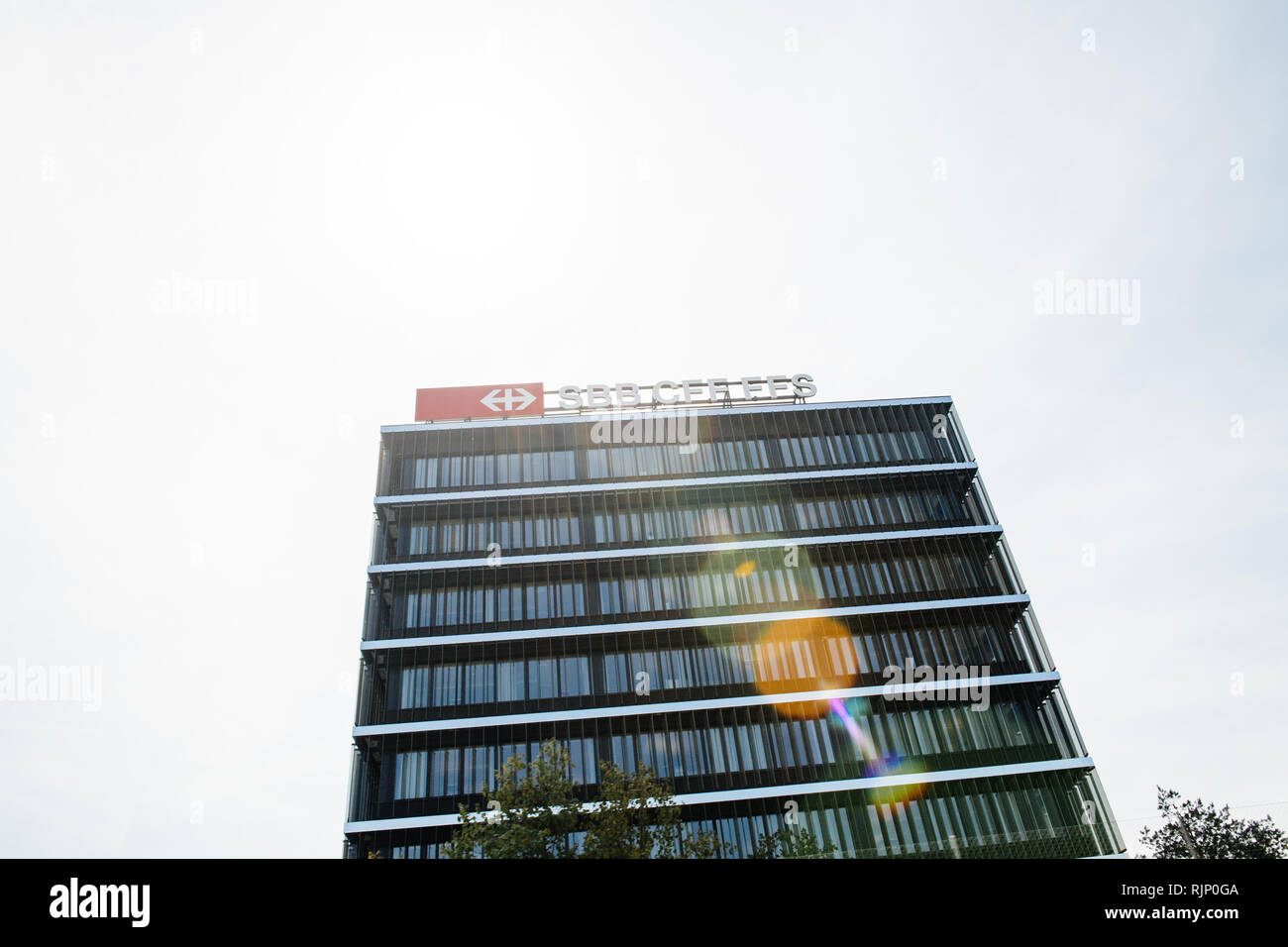 Bern, Schweiz - 17.August 2018: Hauptsitz der Schweizerischen Bundesbahnen Schweizerische Bundesbahnen SBB-CFF-FFS Schriftzug auf dem Dach des Gebäudes Sonnenlicht flare Stockfoto