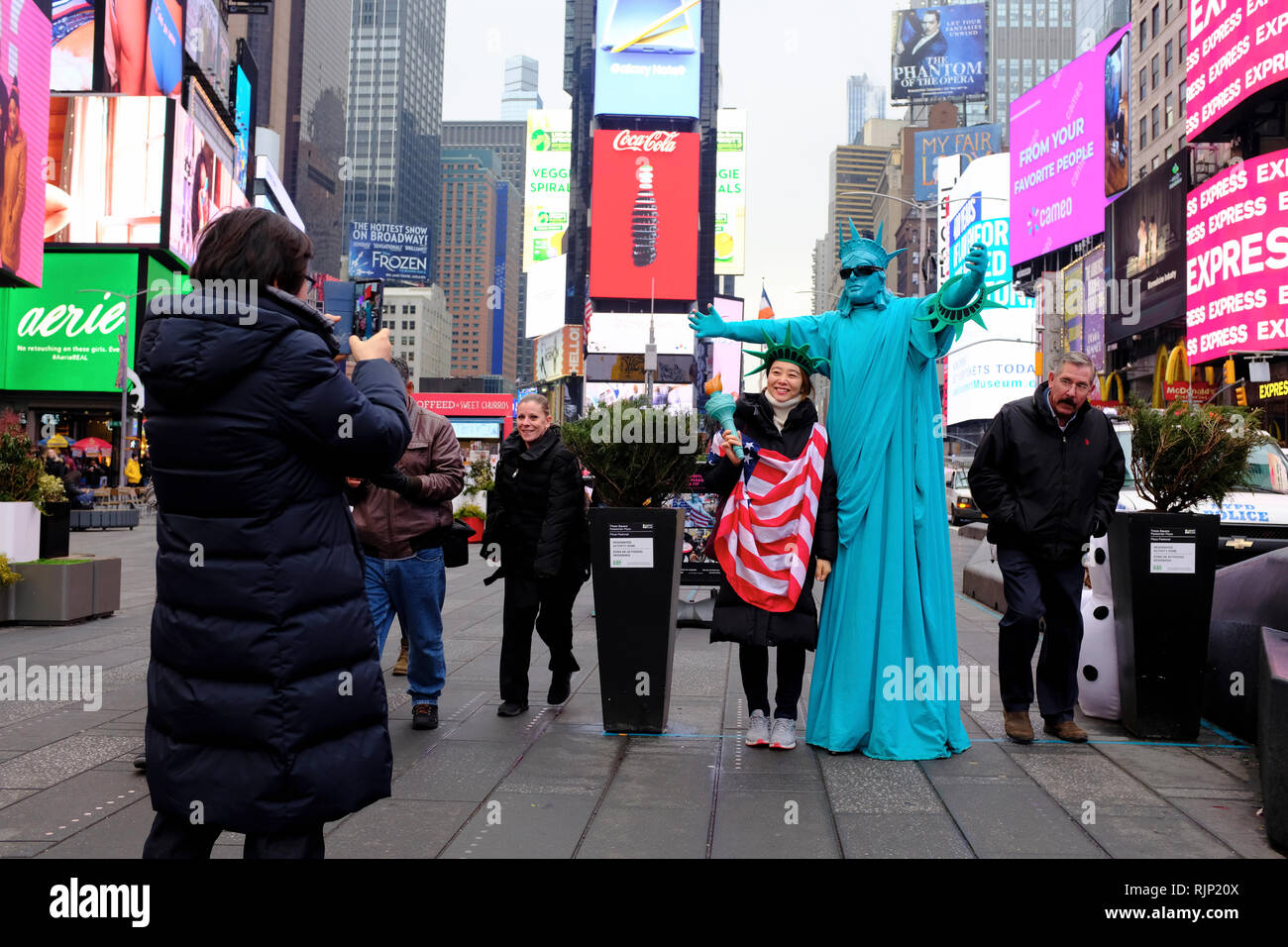 Ein Tourist in ihr Foto mit einem Mann wie die Freiheitsstatue, den Times Square New York City.New York USA gekleidet getroffen. Stockfoto