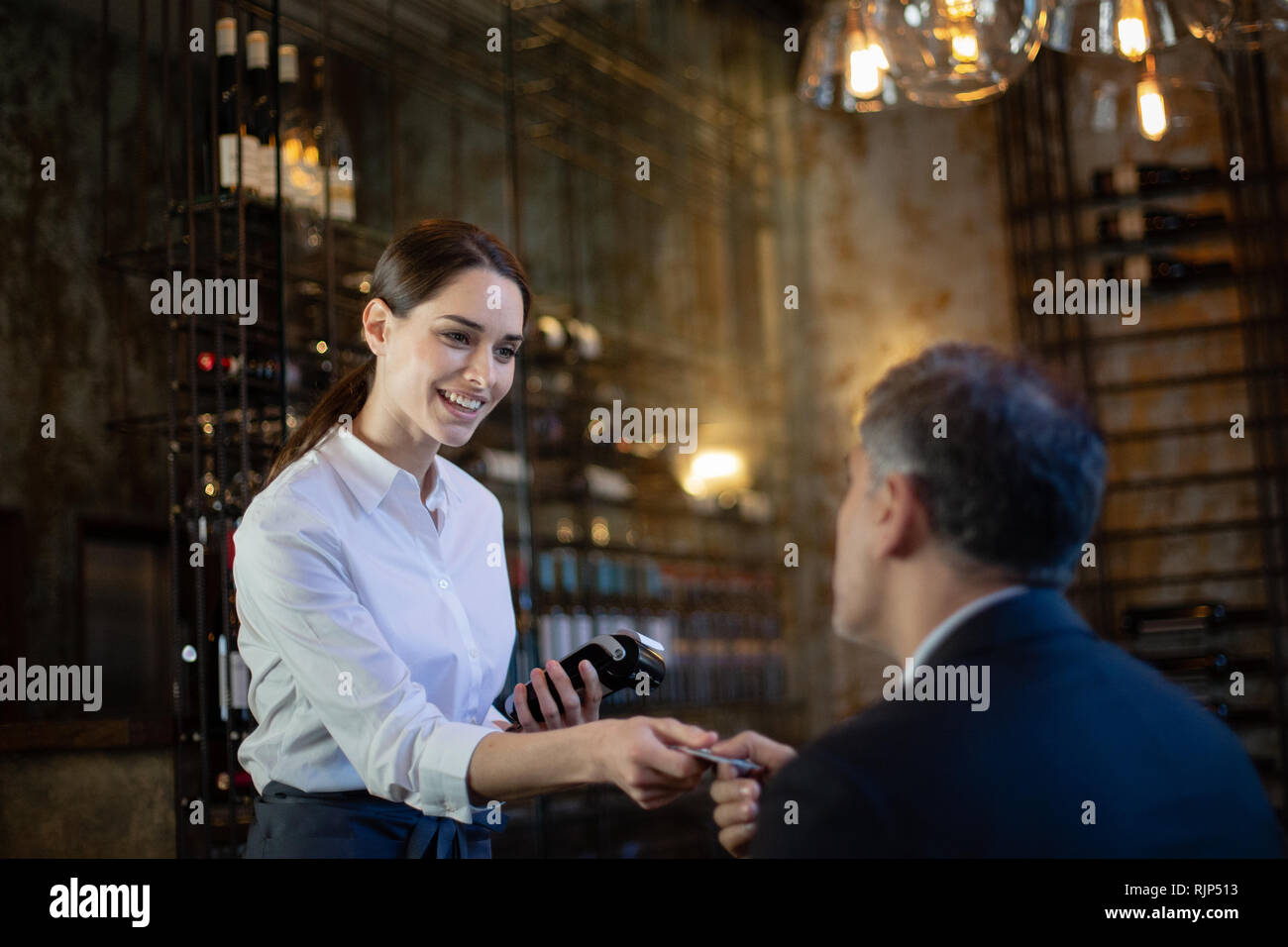 Kellnerin, die Zahlung in einem Restaurant Stockfoto