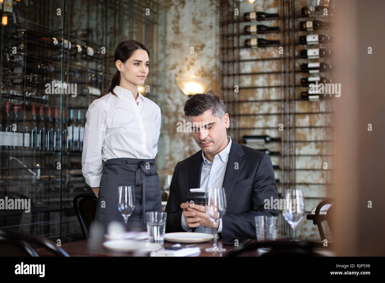 Kellnerin, die Zahlung in einem Restaurant Stockfoto