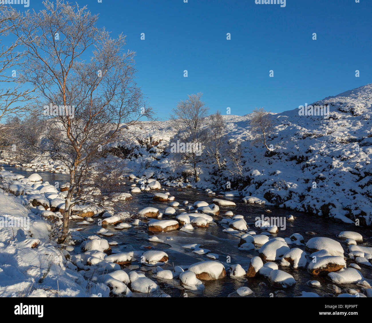 Fluss Etive nach frischem Schneefall auf einem hellen Nachmittag im Winter. Glen Etive, Hochland, Schottland Stockfoto