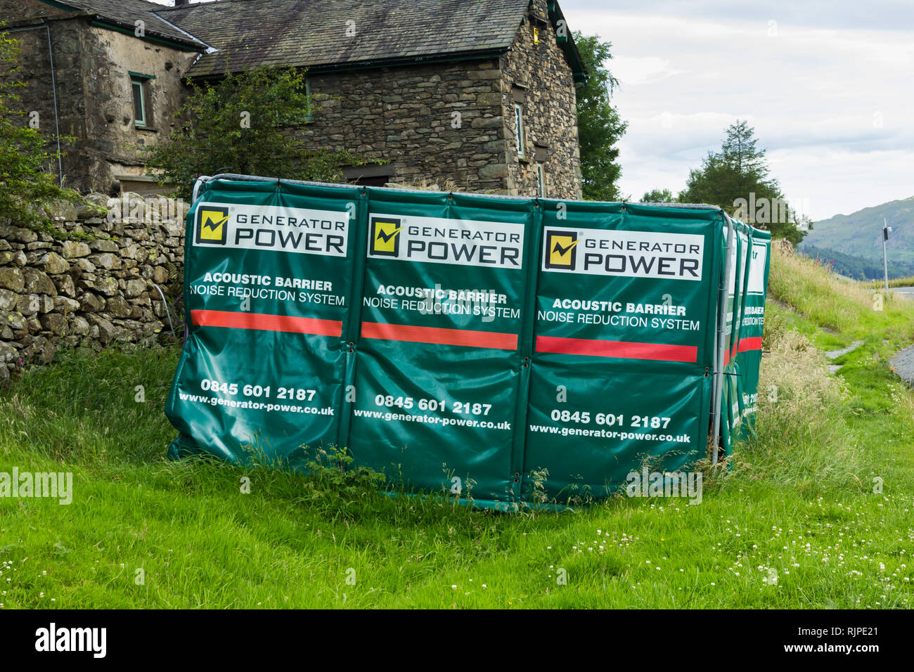 Vorübergehende akustische Barriere rund um einen großen tragbaren Stromerzeuger gelegen außerhalb einer isolierten ländlichen Gebäude im Lake District. Stockfoto