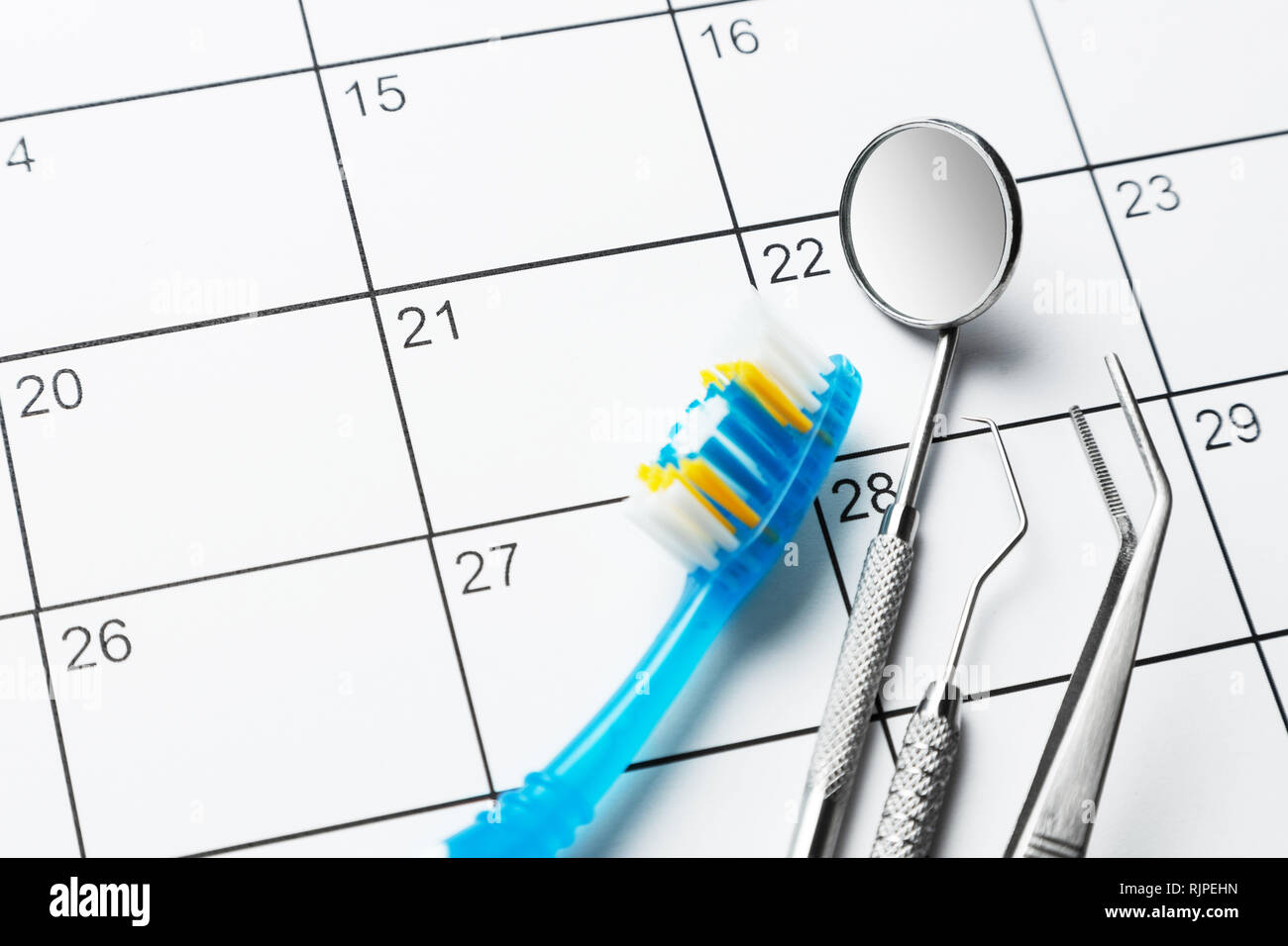 Zahnarzt Hinweis auf dem Kalender. Zahnbürste und eine zahnmedizinische Instrumente Spiegel, Prince, Haken auf dem Kalender. Stockfoto