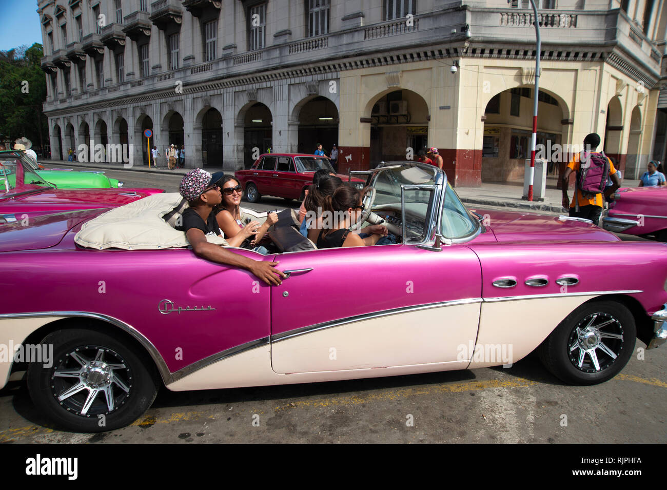 Touristen, die einen kühlen Taxifahrt in einem restaurierten 1950er American Classic Auto auf den Straßen von Havanna Vieja Kuba Stockfoto