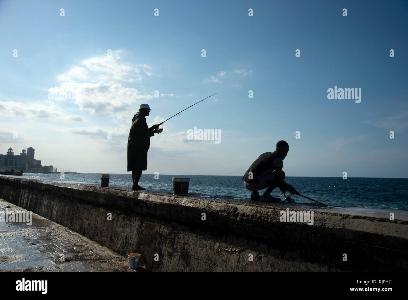 Zwei silhouetted Kubanische Fischer vom Meer Wand am Malecon in Havanna, Kuba Stockfoto