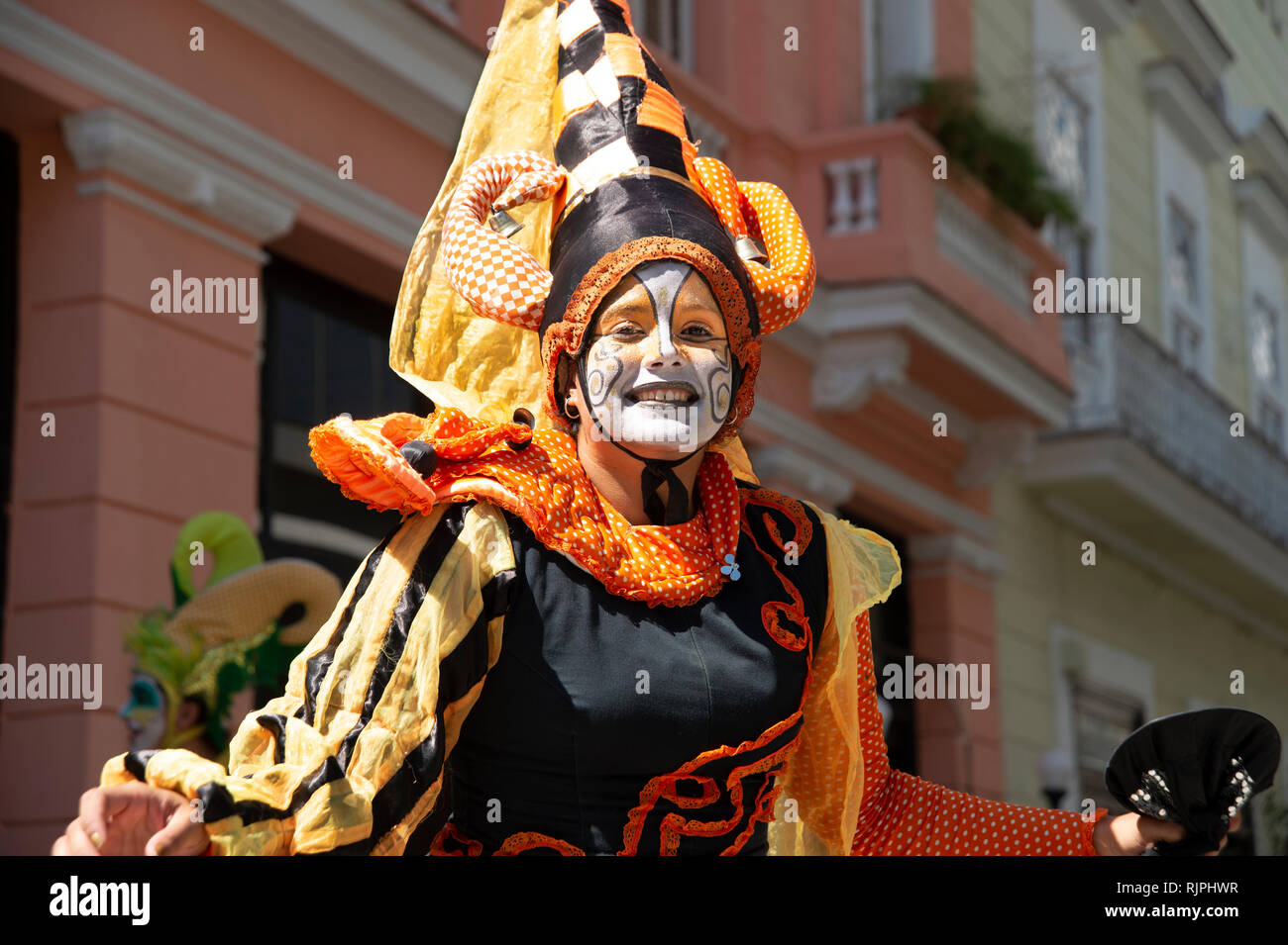 Eine glücklich lächelnde Street Performer in farbenfroher Tracht unterhält die Massen auf den Straßen von Havanna Vieja Kuba Stockfoto
