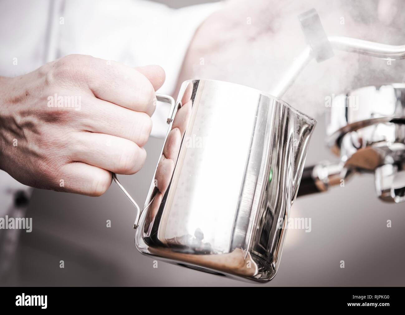 Cappuccino Milch Garen im Edelstahl Milch Krug. Vorbereitung frischen Kaffee. Stockfoto