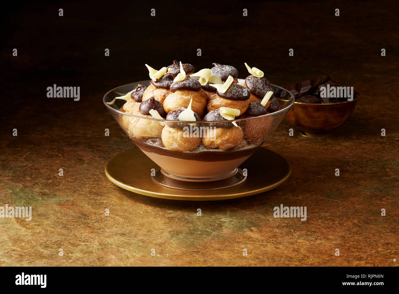 Stillleben mit Schokolade Profiteroles auf Gold Platte, Weihnachten Dessert Stockfoto
