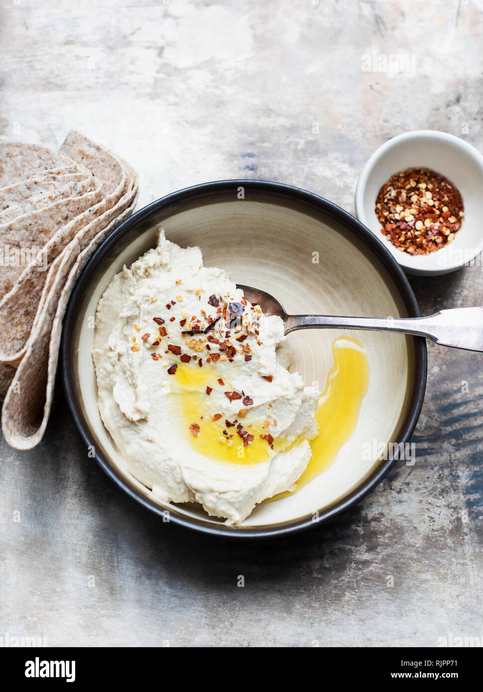 Pita Brot mit Hummus dip, Chiliflocken Stockfoto