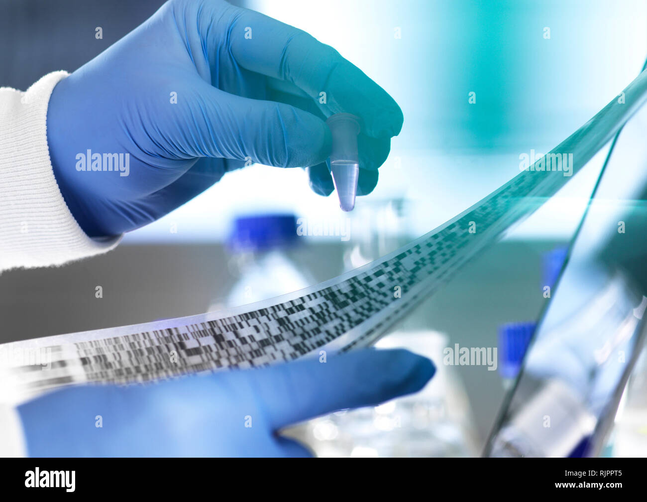 Forschung Wissenschaftler eine Probe in einer Durchstechflasche mit DNA-Ergebnisse auf autoradiogram Gel im Labor, in der Nahaufnahme einer Hand, Stockfoto