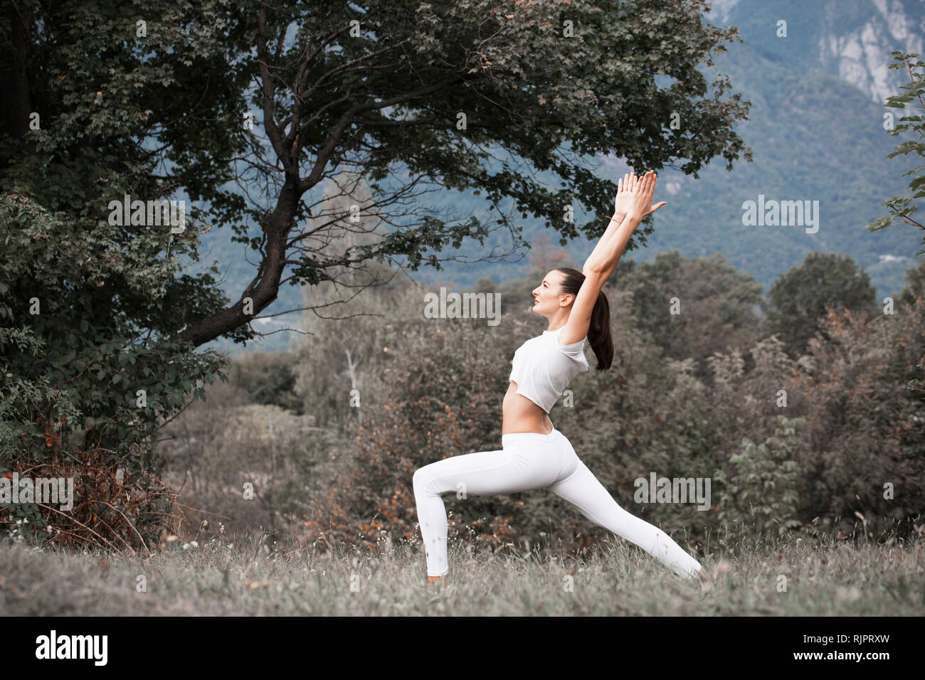 Frau Üben Yoga, Krieger stellen in ländlichen Landschaft Stockfoto