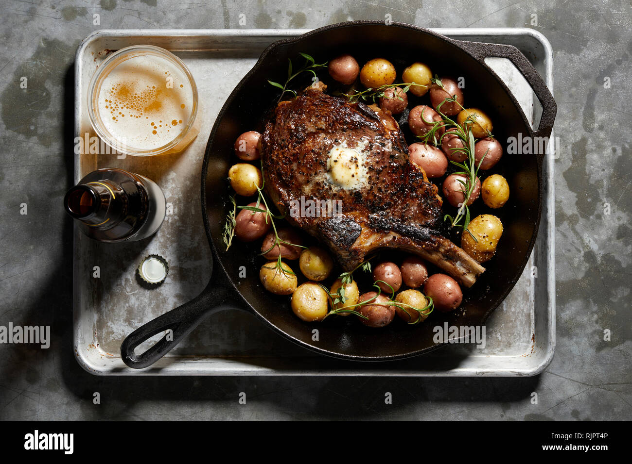 Pfanne mit großen Tomahawk Steak & Kartoffeln, Ansicht von oben Stockfoto