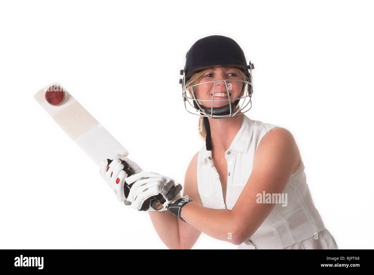 Frau cricketer in einem weißen Kleid mit einem Schutzhelm, shin Pads, Schläger und Ball. Stockfoto