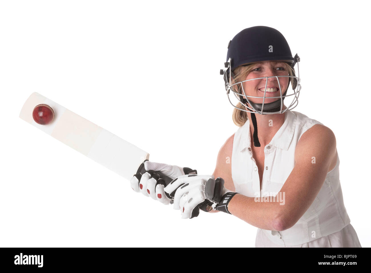 Frau cricketer in einem weißen Kleid mit einem Schutzhelm, shin Pads, Schläger und Ball. Stockfoto