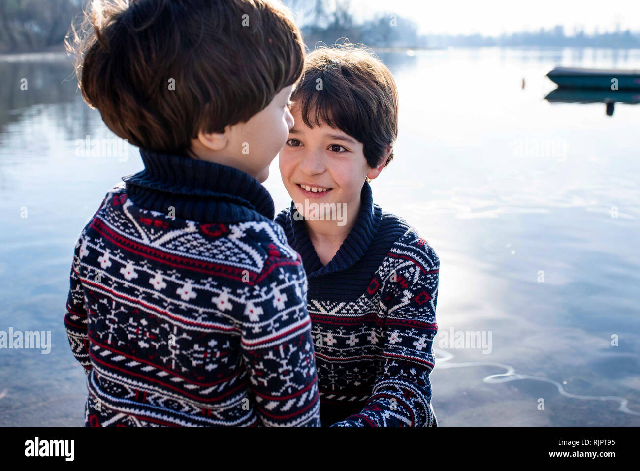 Junge und Kleinkind Bruder in passenden Pullover auf See, Lake Como, Lecco, Lombardei, Italien Stockfoto