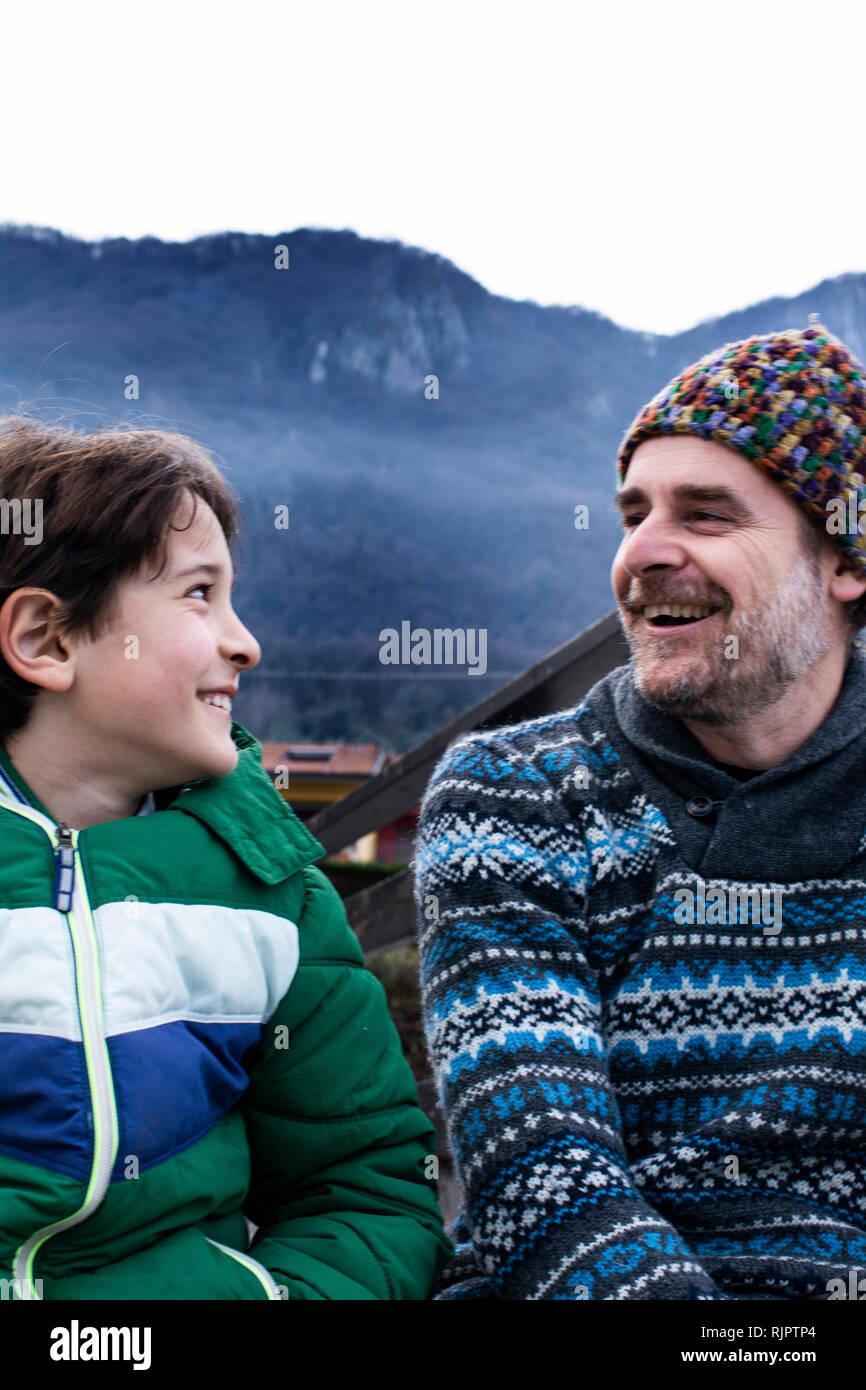 Junge und Vater sich einander am Pier am See, Comer See, Onno, Lombardei, Italien Stockfoto