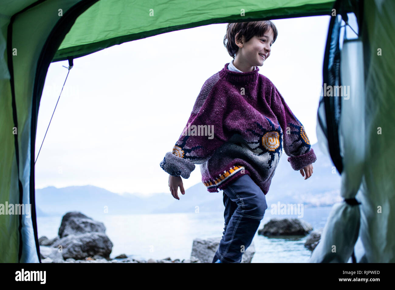 Junge spielt außerhalb Zelt auf See, Comer See, Onno, Lombardei, Italien Stockfoto