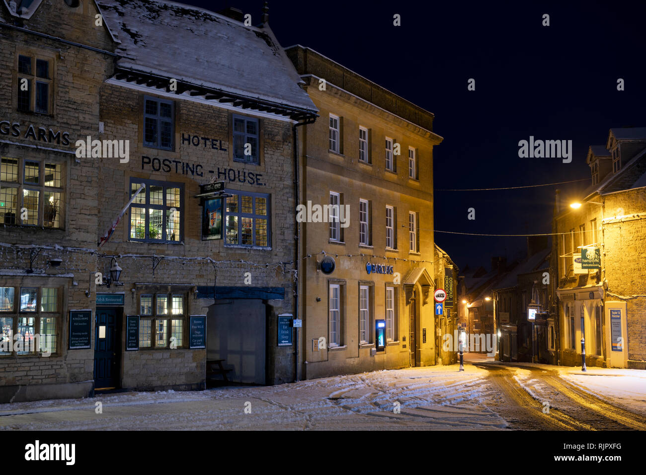 Kings Arms Pub in der Verschneiten Marktplatz vor der Morgendämmerung. Verstauen auf der Wold, Cotswolds, Gloucestershire, England Stockfoto
