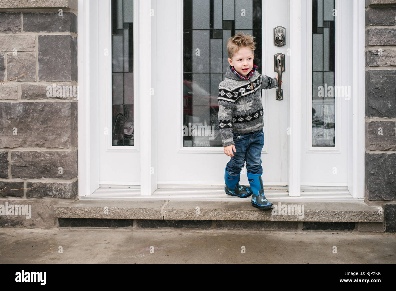 Junge schließenden Tür Haus zu verlassen Stockfoto