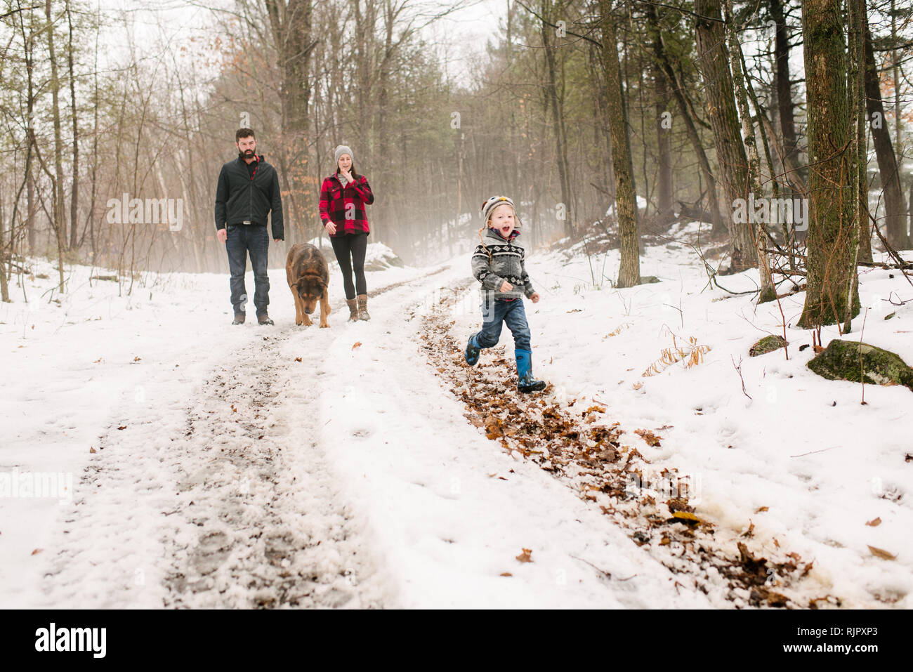 Familie mit Hund auf Spaziergang im Schnee Landschaft Stockfoto