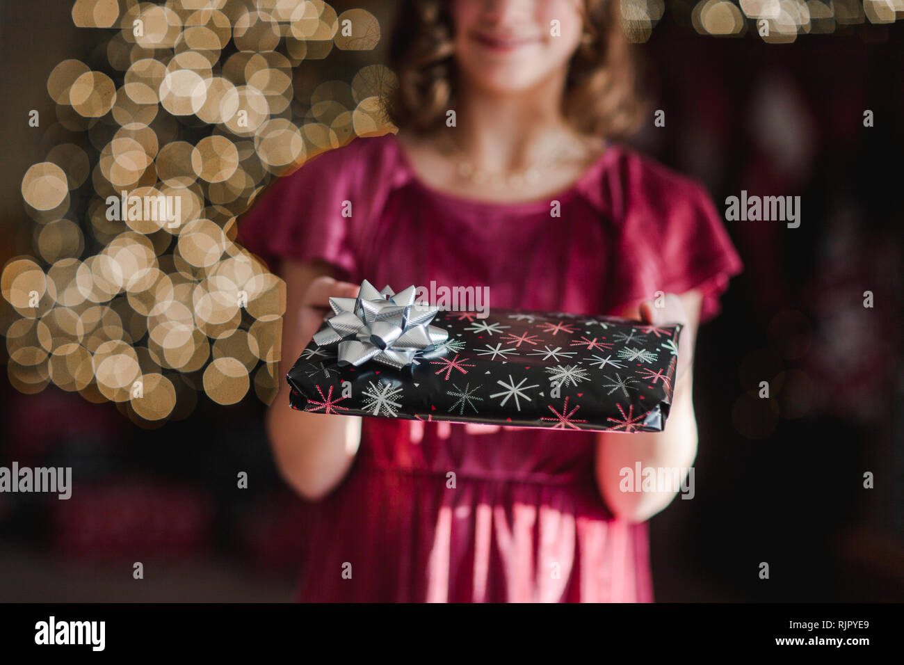 Mädchen hält Weihnachtsgeschenk Stockfoto