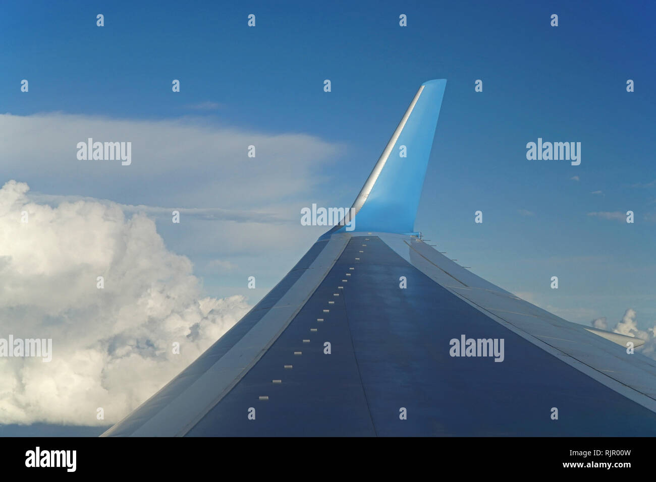 Blick auf den Flügel eines Flugzeuges im Flug vor blauem Himmel Stockfoto