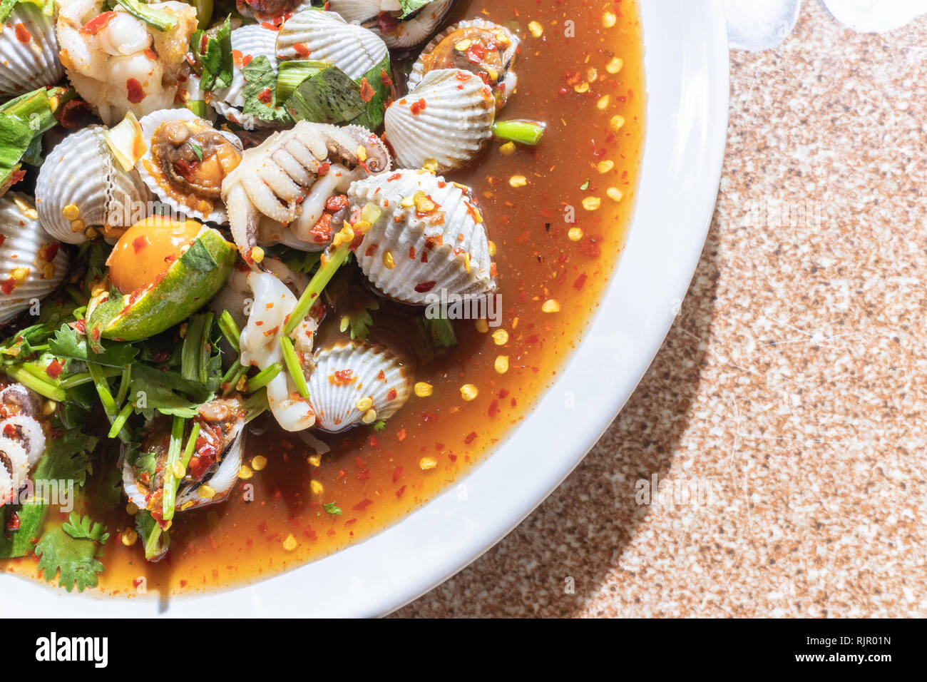 Som-Tum, Papaya Salat Meeresfrüchte Blut Herzmuscheln und Tintenfisch. Stockfoto