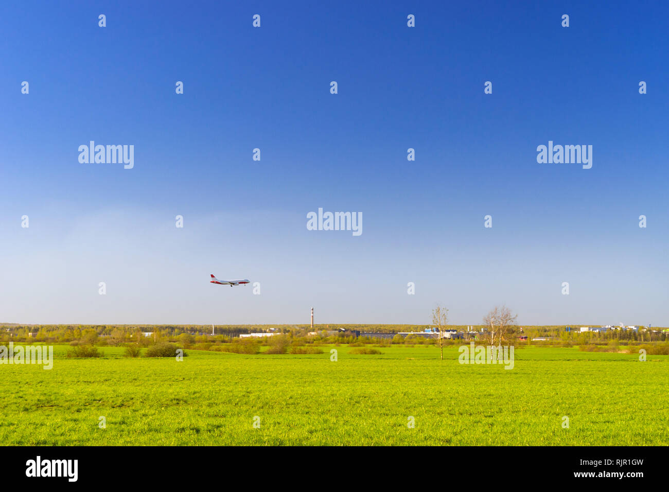 Passagierflugzeug landet auf Start- und Landebahn am Flughafen Pulkowo. Jets am Himmel über dem Feld. Passagier- und Frachtverkehr auf den großen internationalen Flughafen von St. Petersburg, Russland Stockfoto