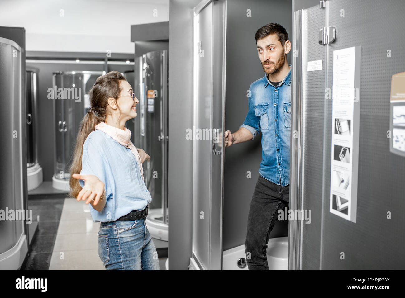 Junges Paar Auswahl einer neuen Duschkabine im Gebäude shop mit Sanitär Möbel Stockfoto