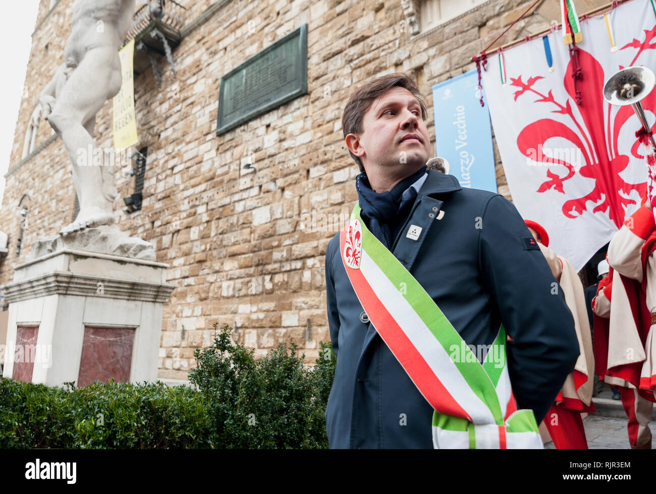 Der Bürgermeister von Florenz Dario Nardella mit bürgermeisterlicher Schärpe während einer öffentlichen Zeremonie. Hinter ihm, den Palazzo Vecchio. Stockfoto