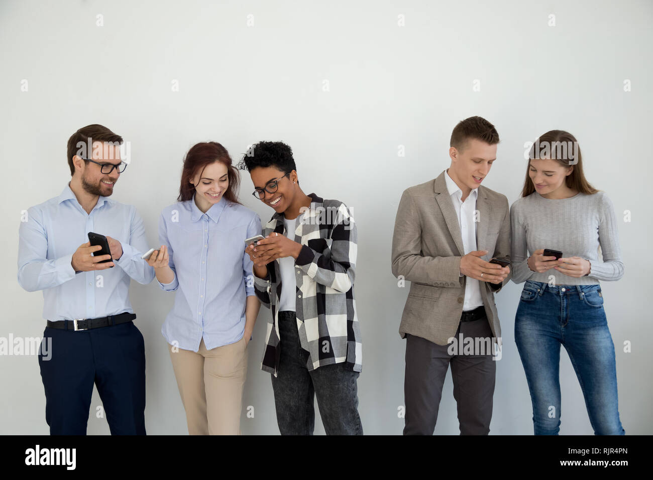 Glücklich, multi-ethnische Freunde oder Geschäftsleute, die sich mit Handys sprechen Stockfoto
