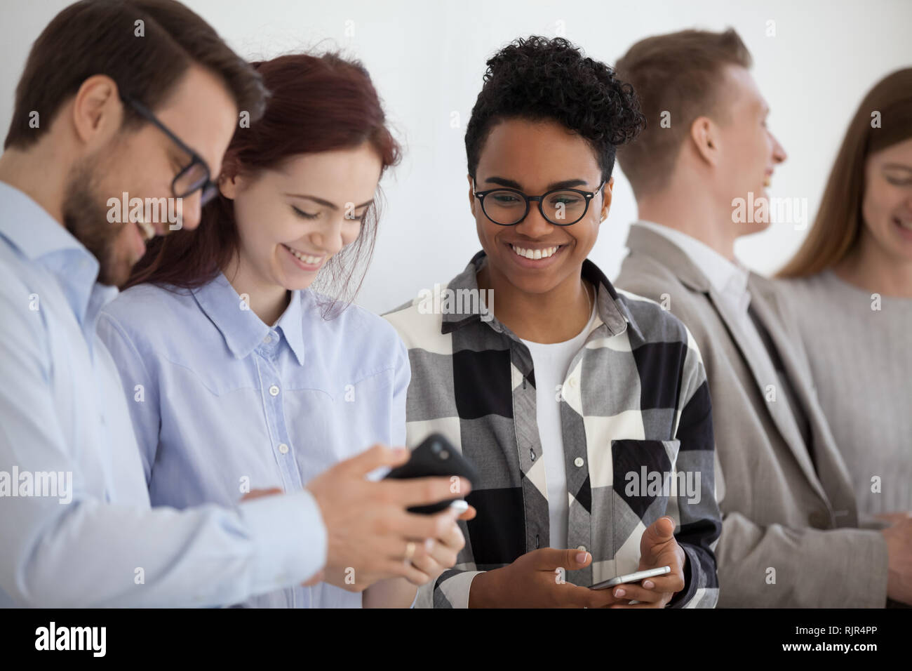 Lächelnd multi-ethnischen Menschen holding Telefone Spaß mit mobilen Geräten Stockfoto