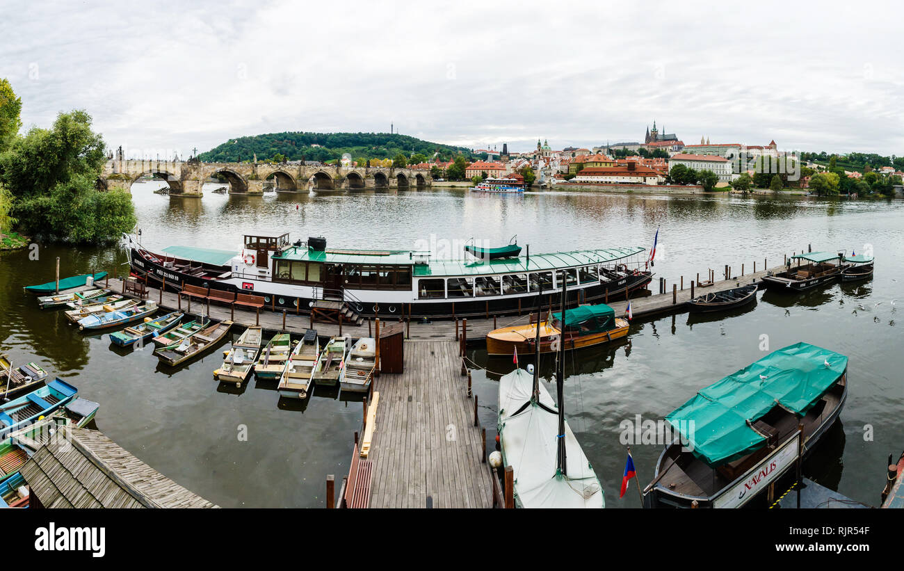 Boot Dock an der Moldau neben Karlsbrücke mit Burg, die St. Vitus Kathedrale und Petrin Hügel im Hintergrund, Prag, Tschechische Republik Stockfoto